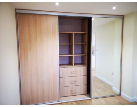 Built in wardrobe with sliding doors includes drawers and shelves